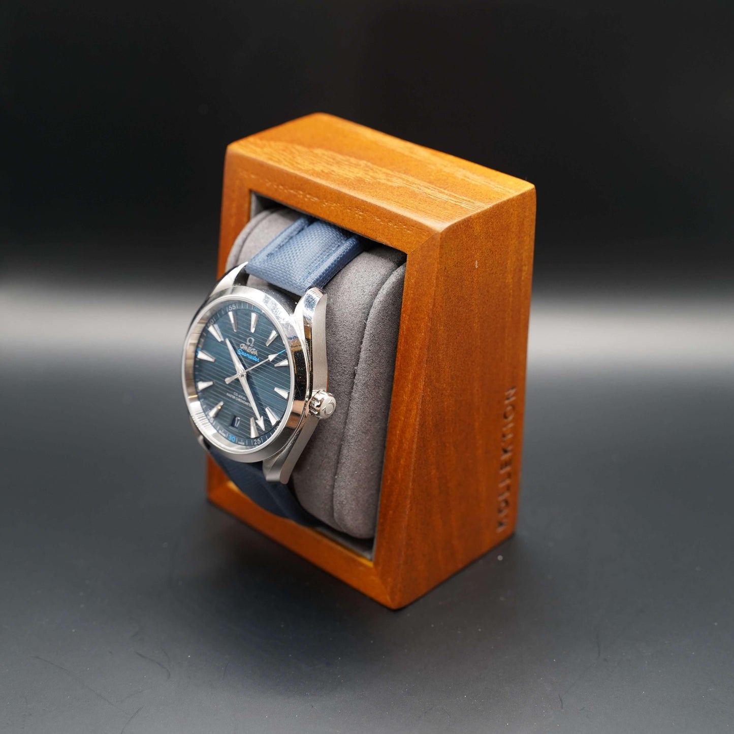 A grey wooden watch case with a microsuede interior. This stylish and functional case is made of high-quality materials and is available in both beige and grey.